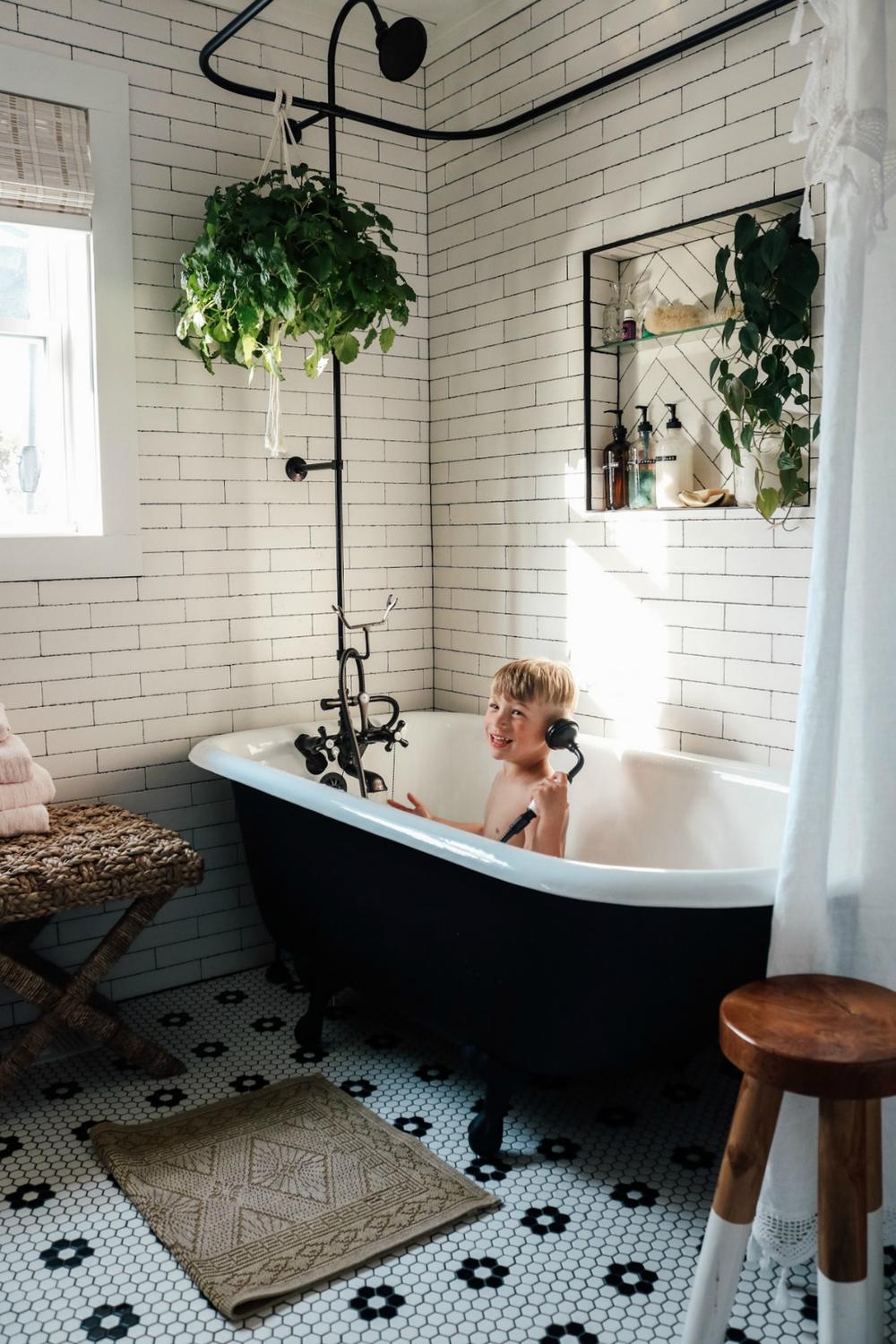 Charming bathroom featuring a classic black clawfoot tub with dual shower functionality.
