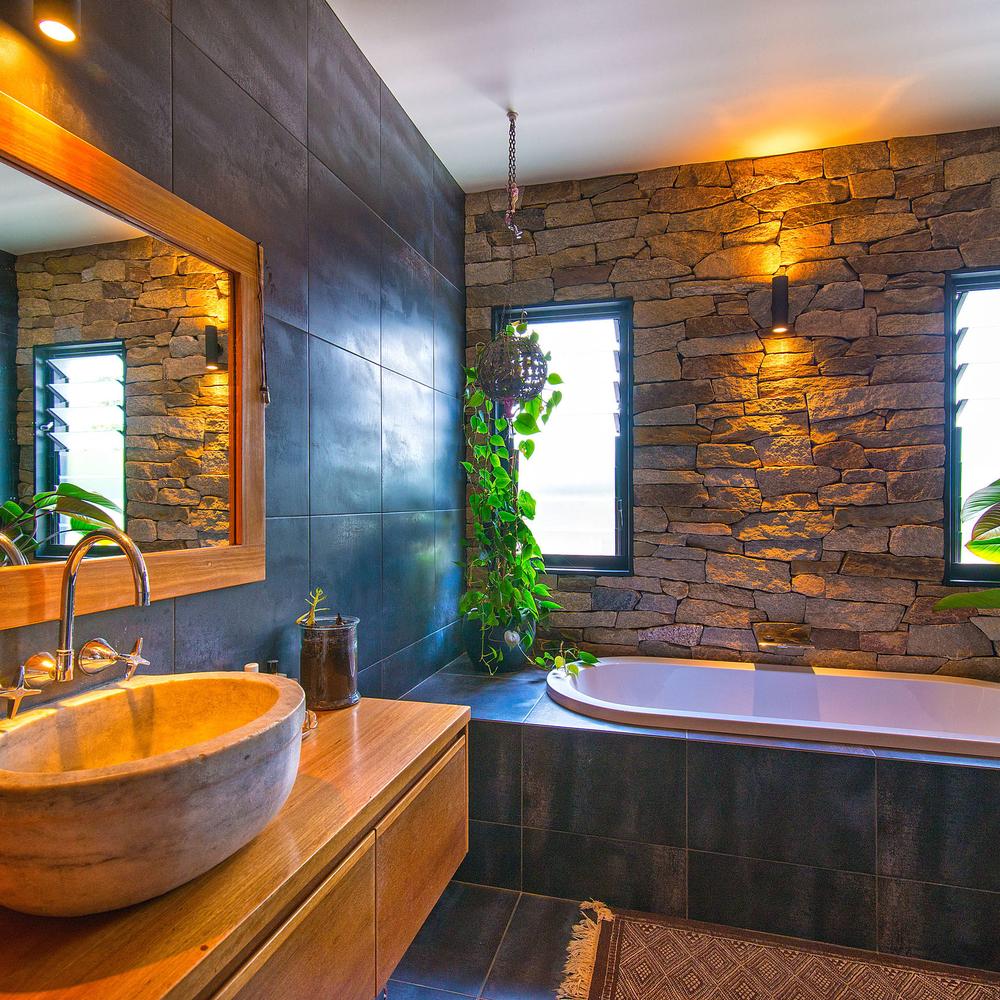 Bathroom showcasing rustic stone elements and greenery