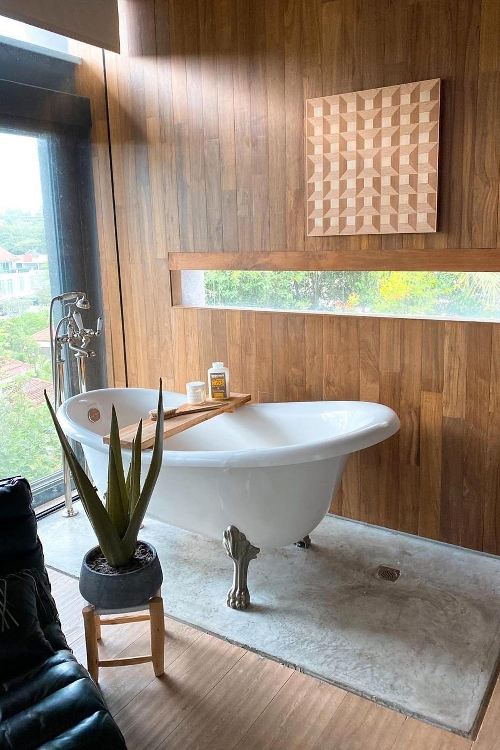 Baño acogedor con bañera estilo clawfoot y madera decorativa