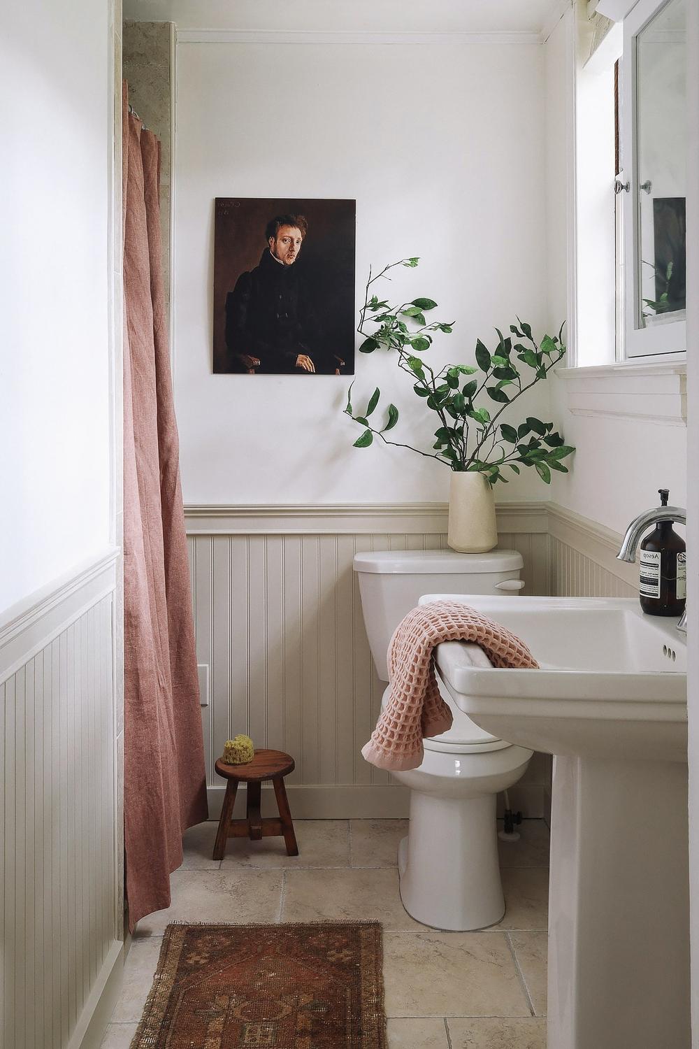 Elegant bathroom featuring white beadboard and neutral accents