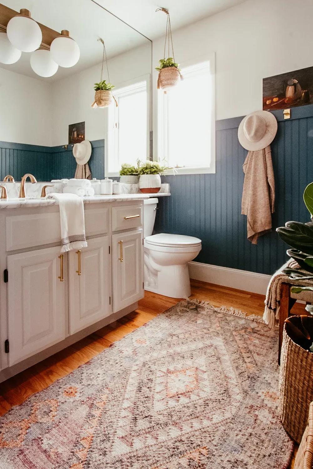Cozy bathroom characterized by stylish beadboard and personal decorative elements