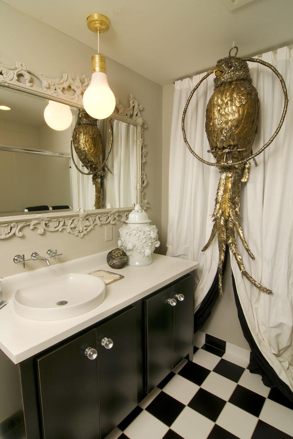 Baño chic con detalles artísticos en negro y oro