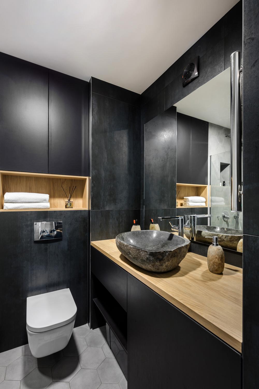 Chic bathroom design featuring bold black elements against light wood finishes.