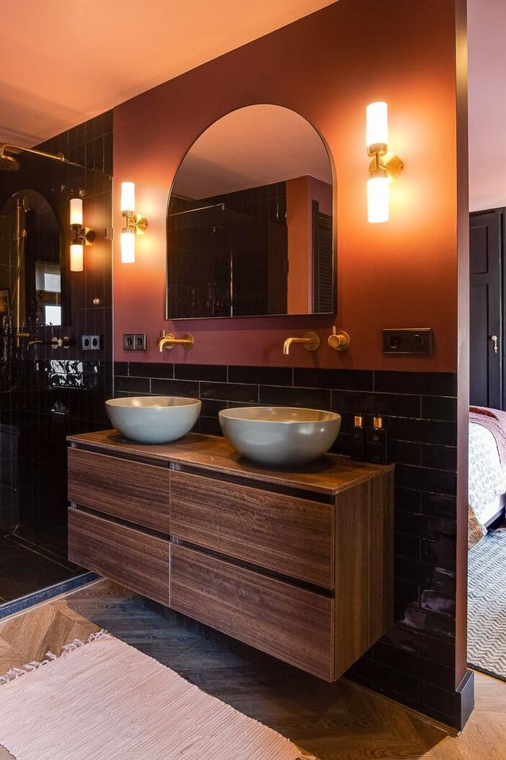 Stylish modern bathroom design featuring deep burgundy walls complemented by black tiles and warm wooden accents.