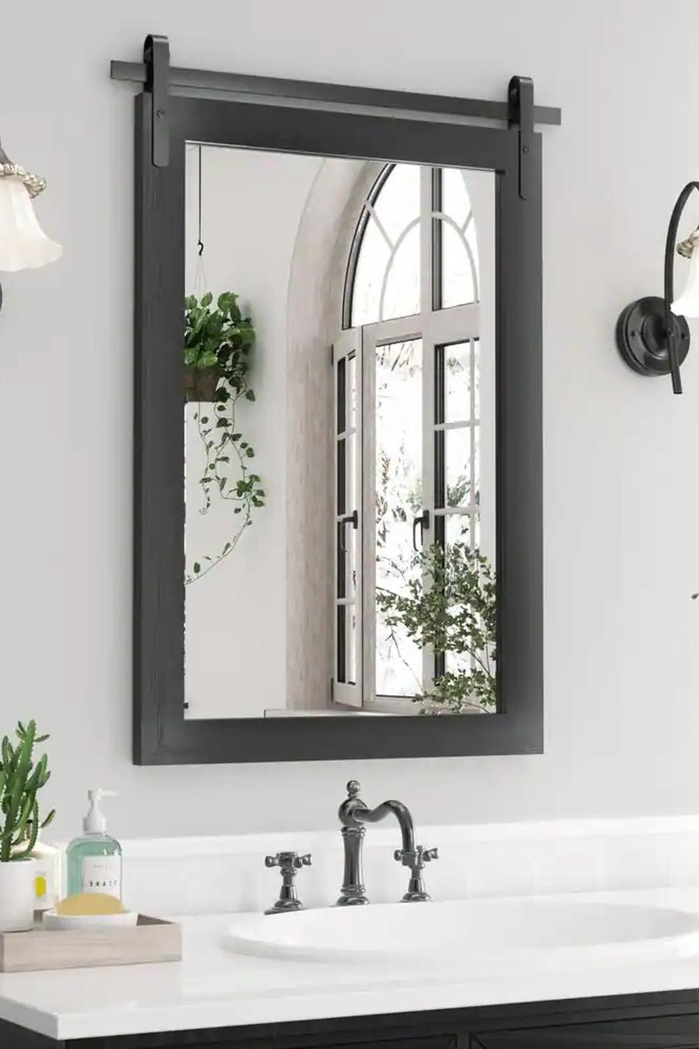 Robust black bathroom mirror with barn door-style top.