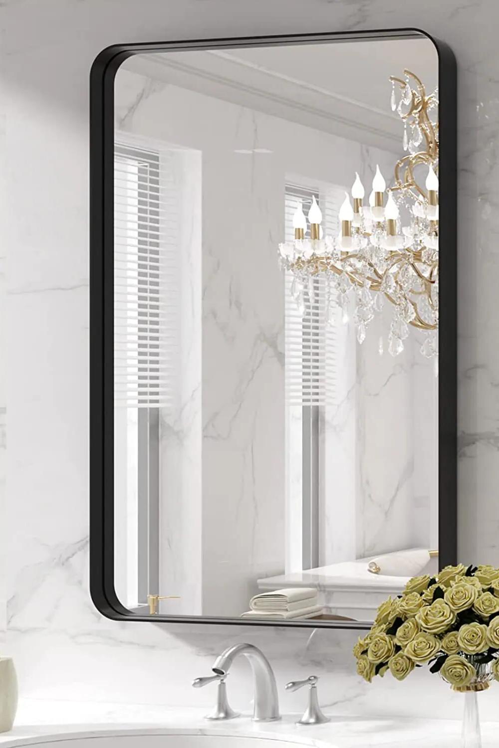 Modern bathroom featuring a stylish black mirror framed in a luxurious marble background.