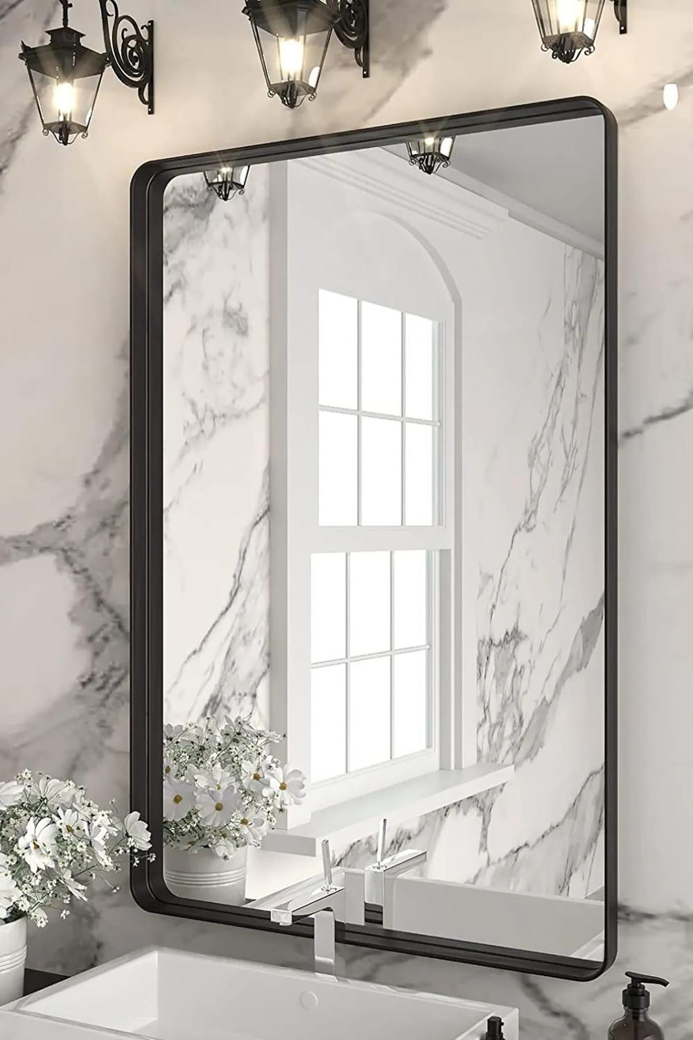 Minimalist black frame mirror juxtaposed with chic bathroom decor.