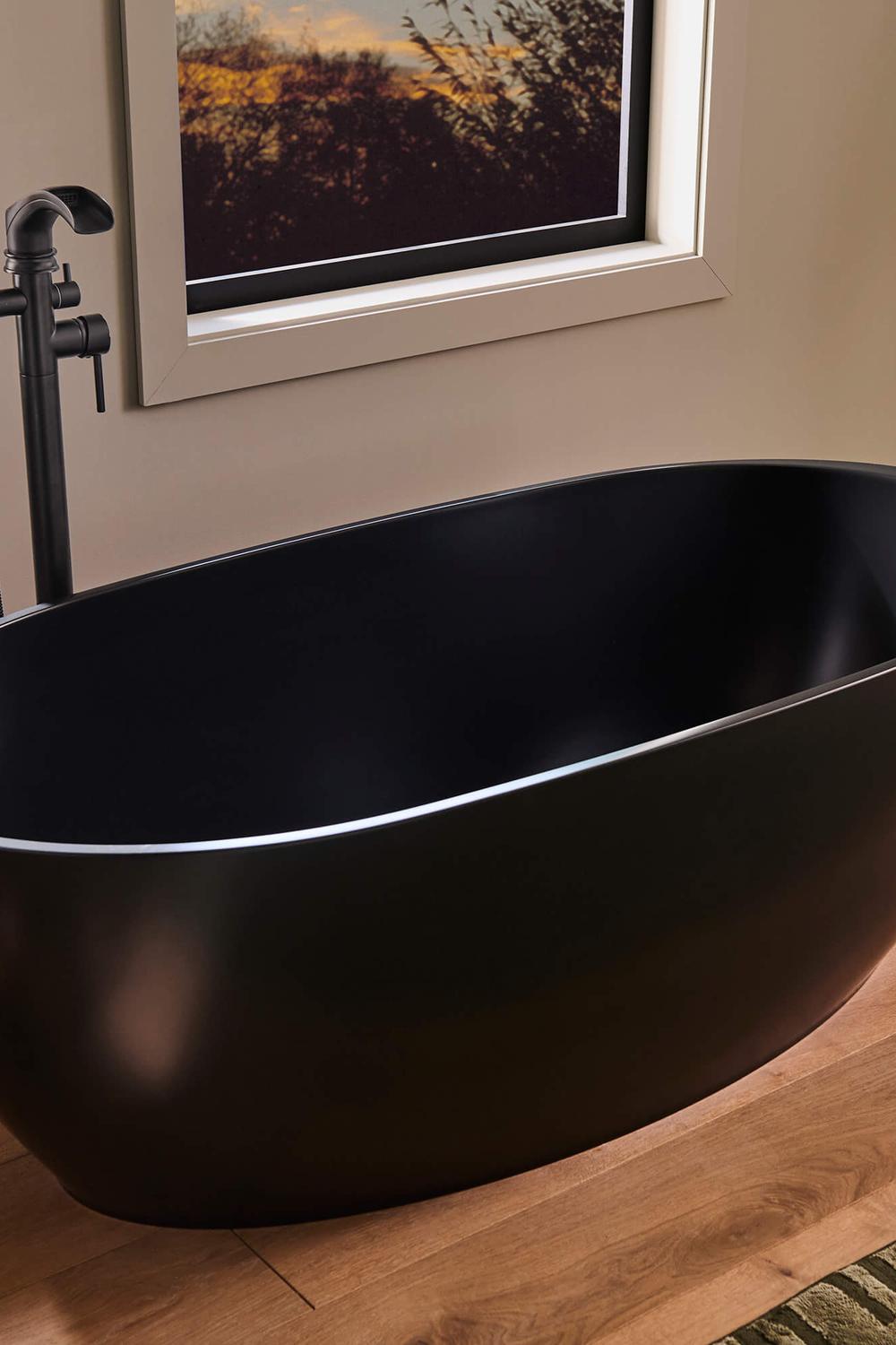 Luxurious bathroom with a black bathtub accented with gold fixtures and elegant decor.