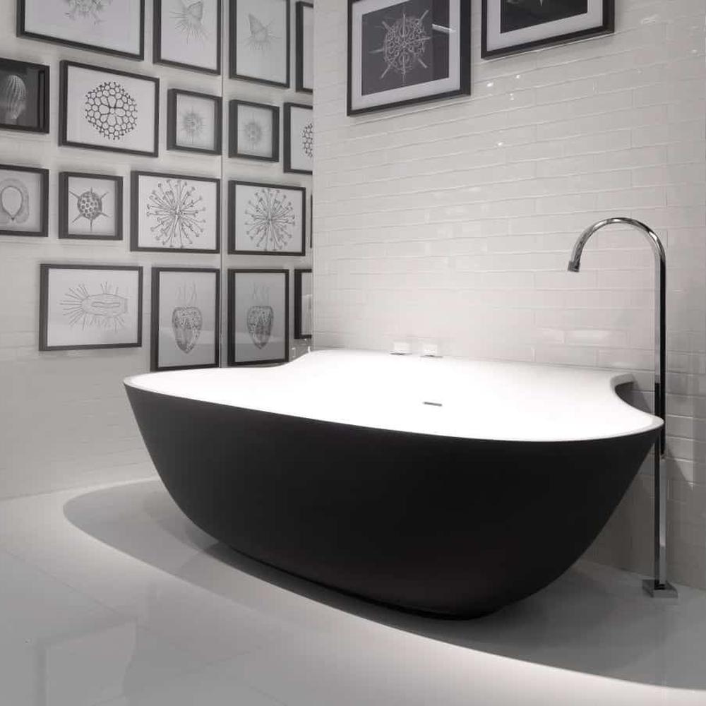 Elegant modern bathroom with natural light flooding around a black bathtub.