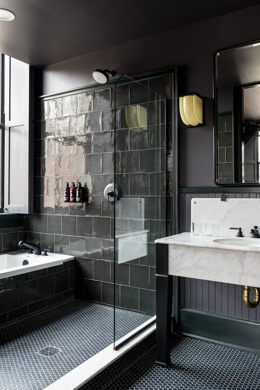 Baño moderno con bañera negra y mosaico