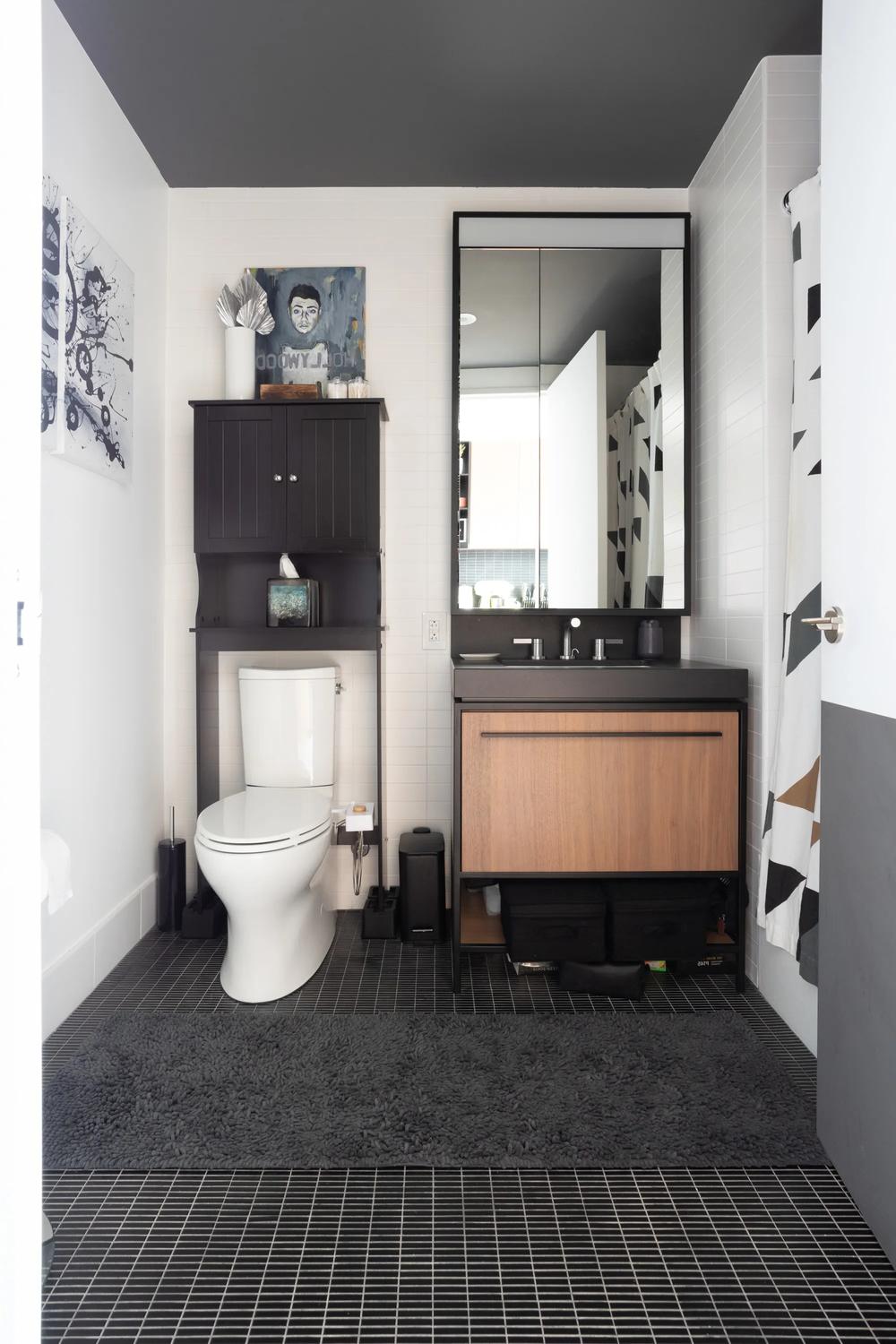 Baño con suelo negro y decoración artística