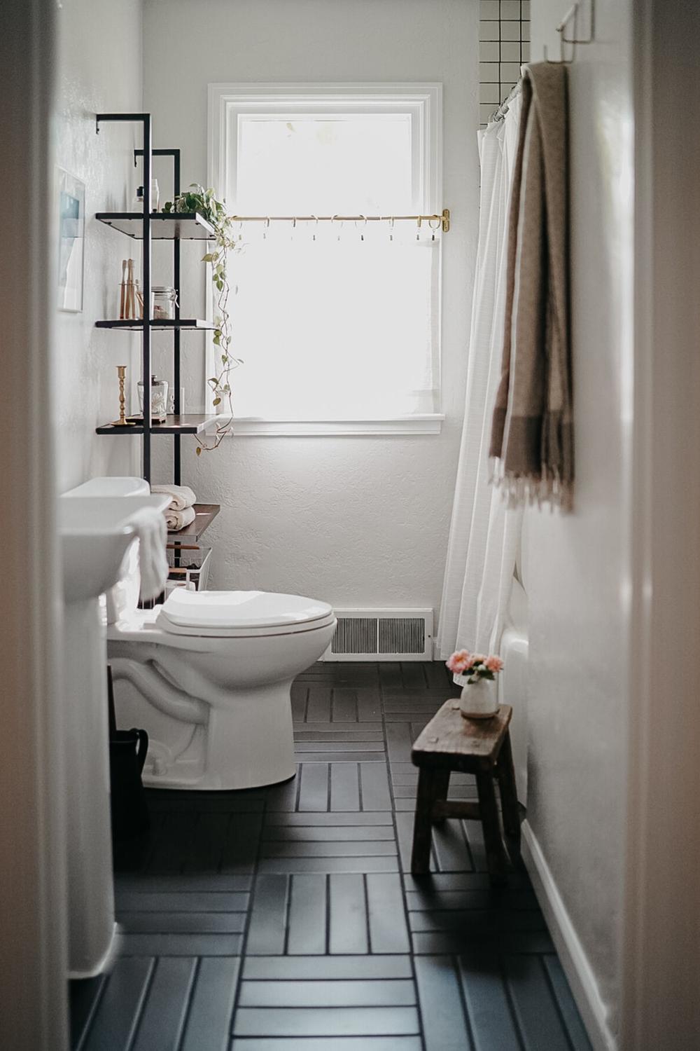 Baño minimalista con suelo negro en forma de espiga