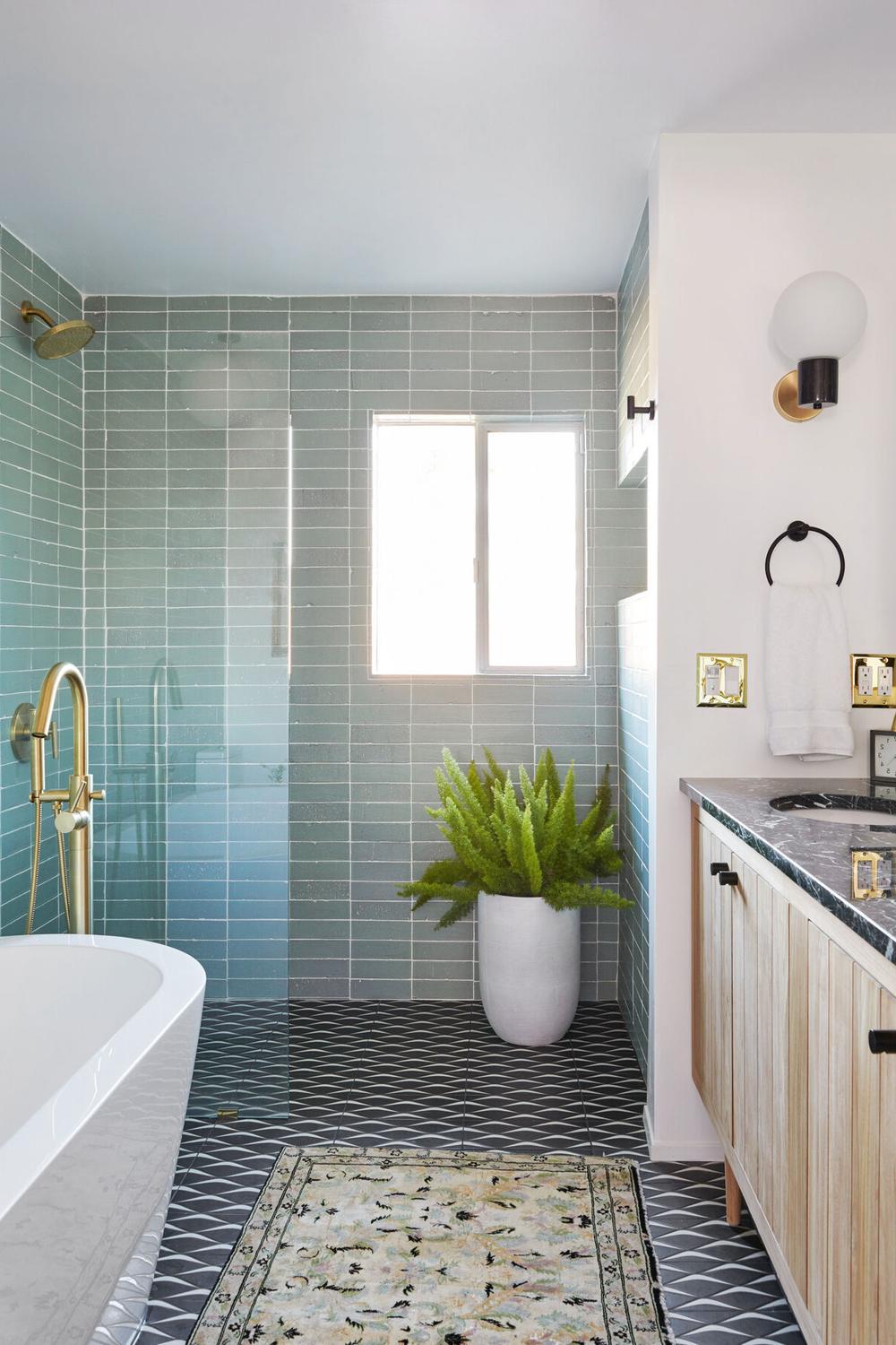 Baño moderno con suelo negro y azulejos claros