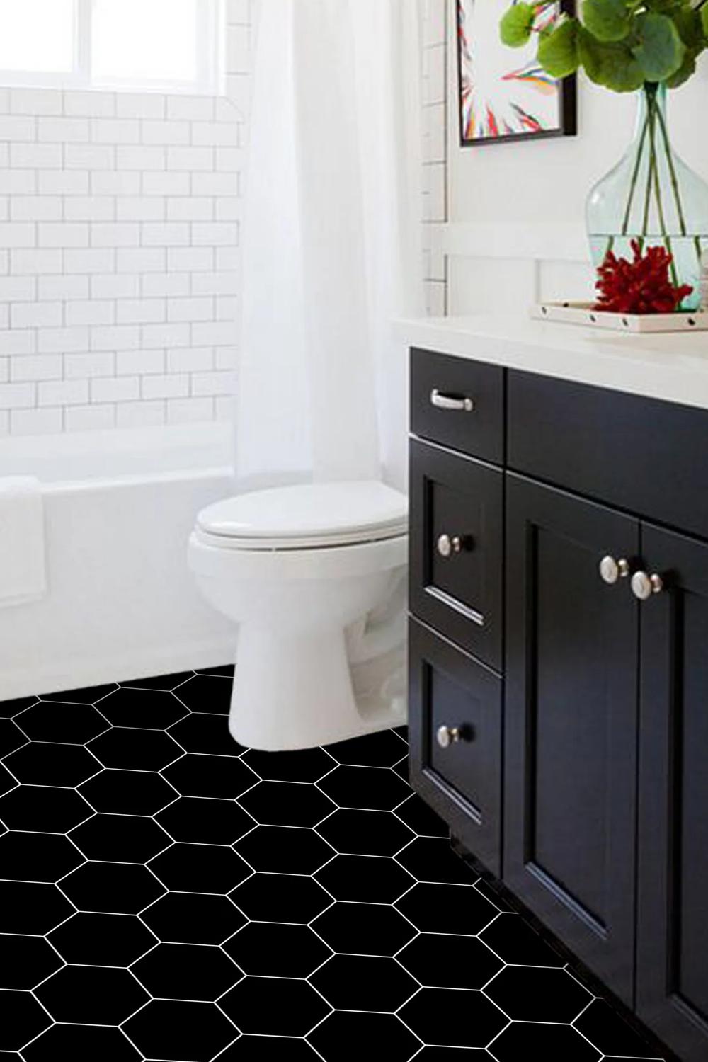 Baño chic con azulejos hexagonales negros en el suelo y mueble de baño oscuro