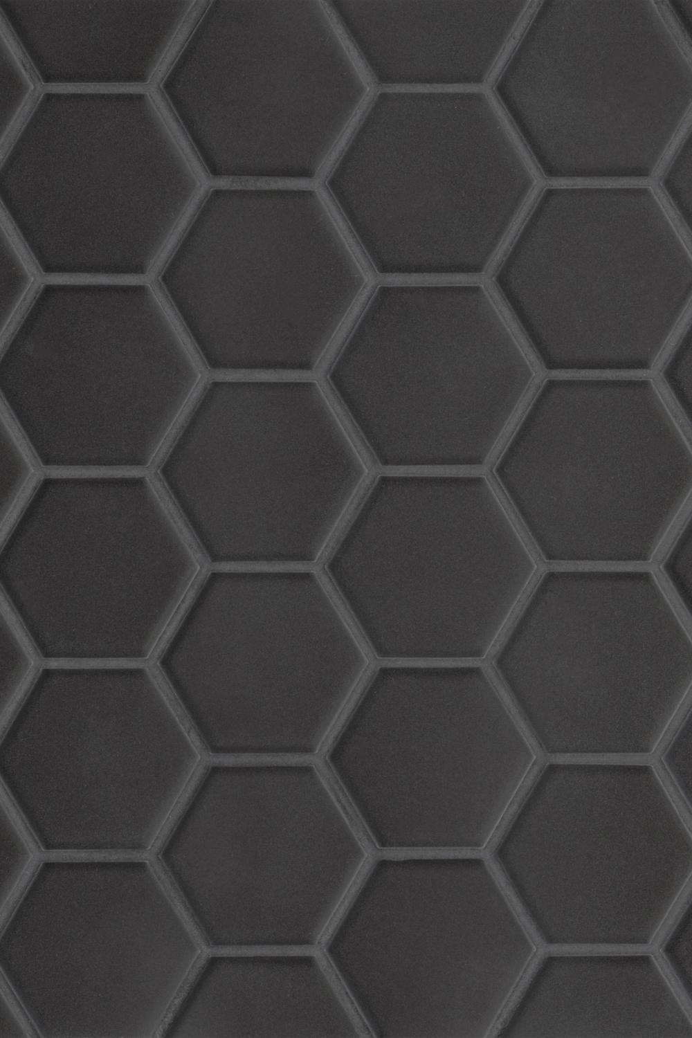 Textured wall featuring mixed sizes of black hexagon tiles for a dynamic appearance.