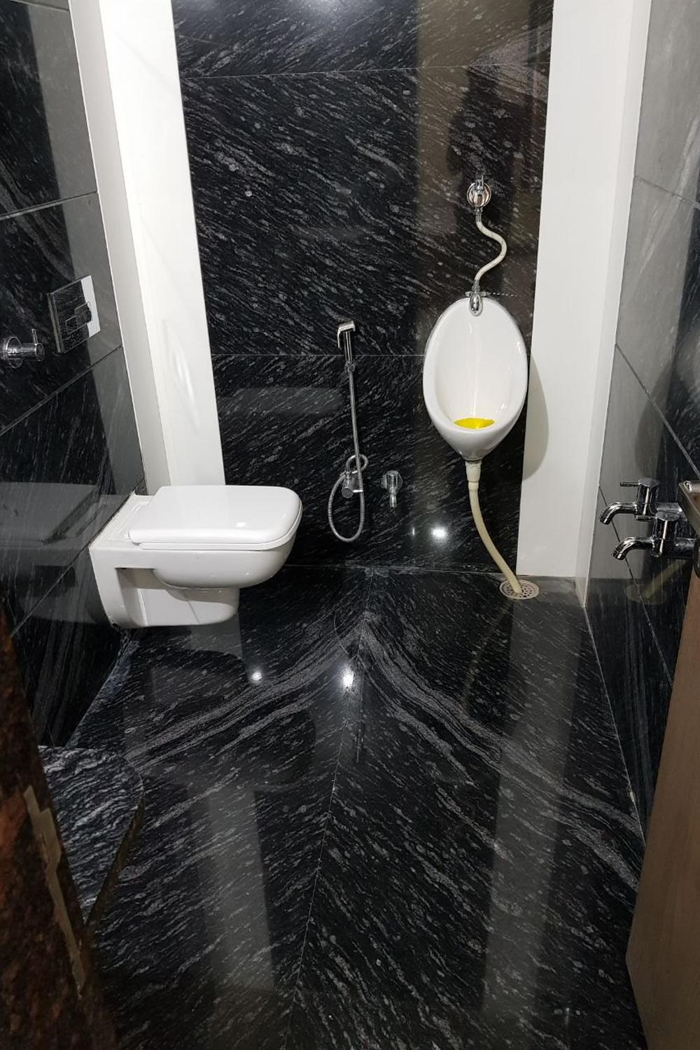 Un baño moderno con funcionalidad en mármol negro