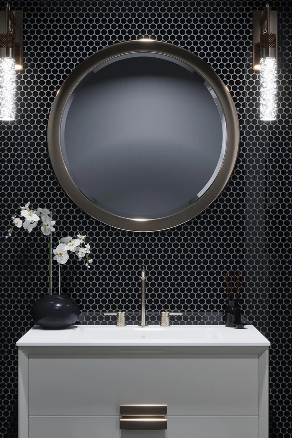 Baño moderno con azulejos negros y accesorios cálidos