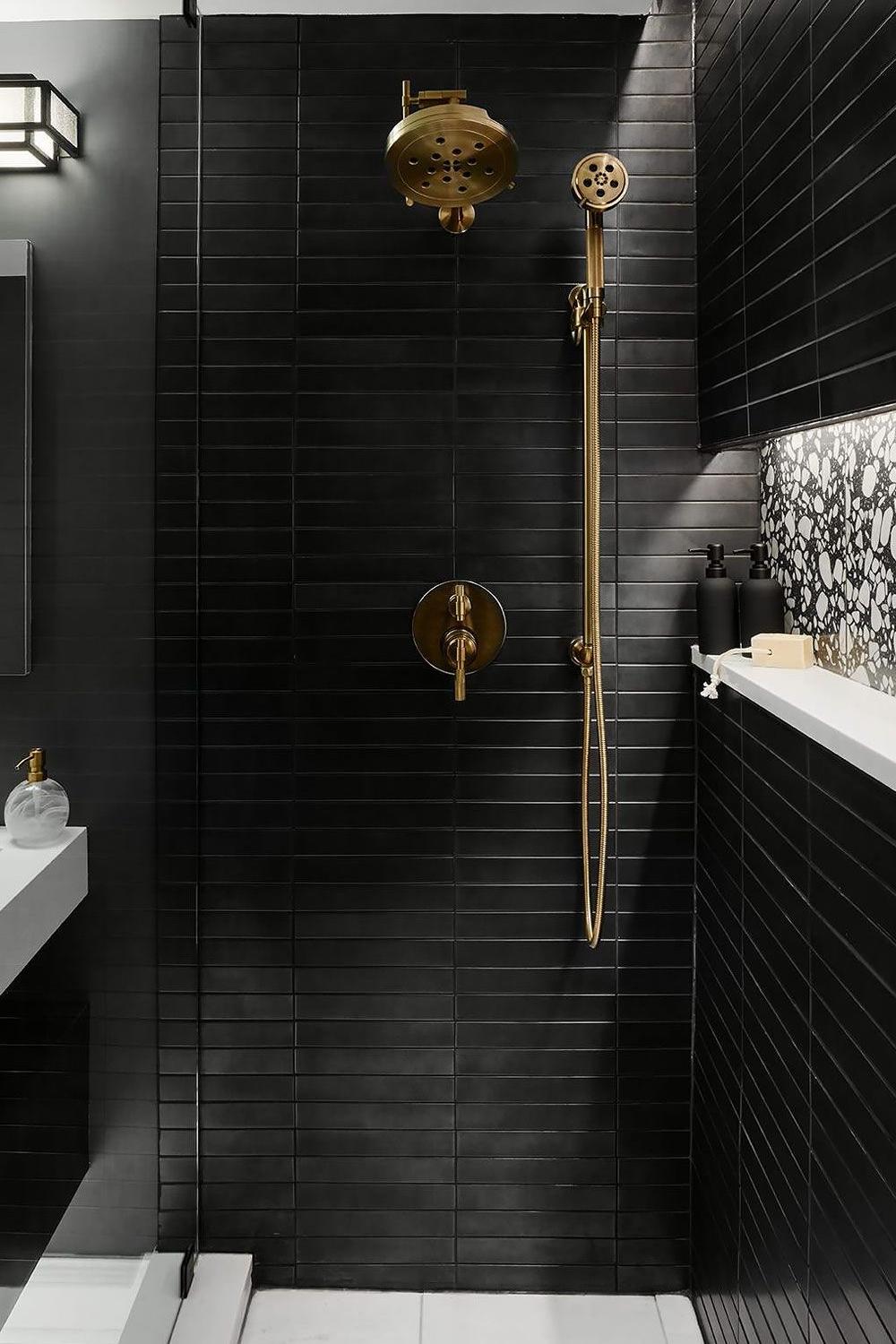Baño moderno con ducha negra y detalles en dorado