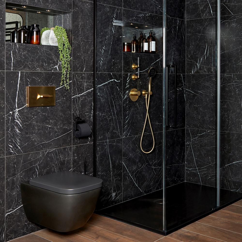 Baño sofisticado y lujoso con ducha negra y elementos decorativos