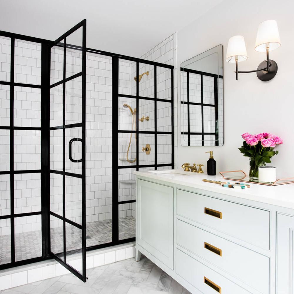 Baño con ducha negra y detalles dorados