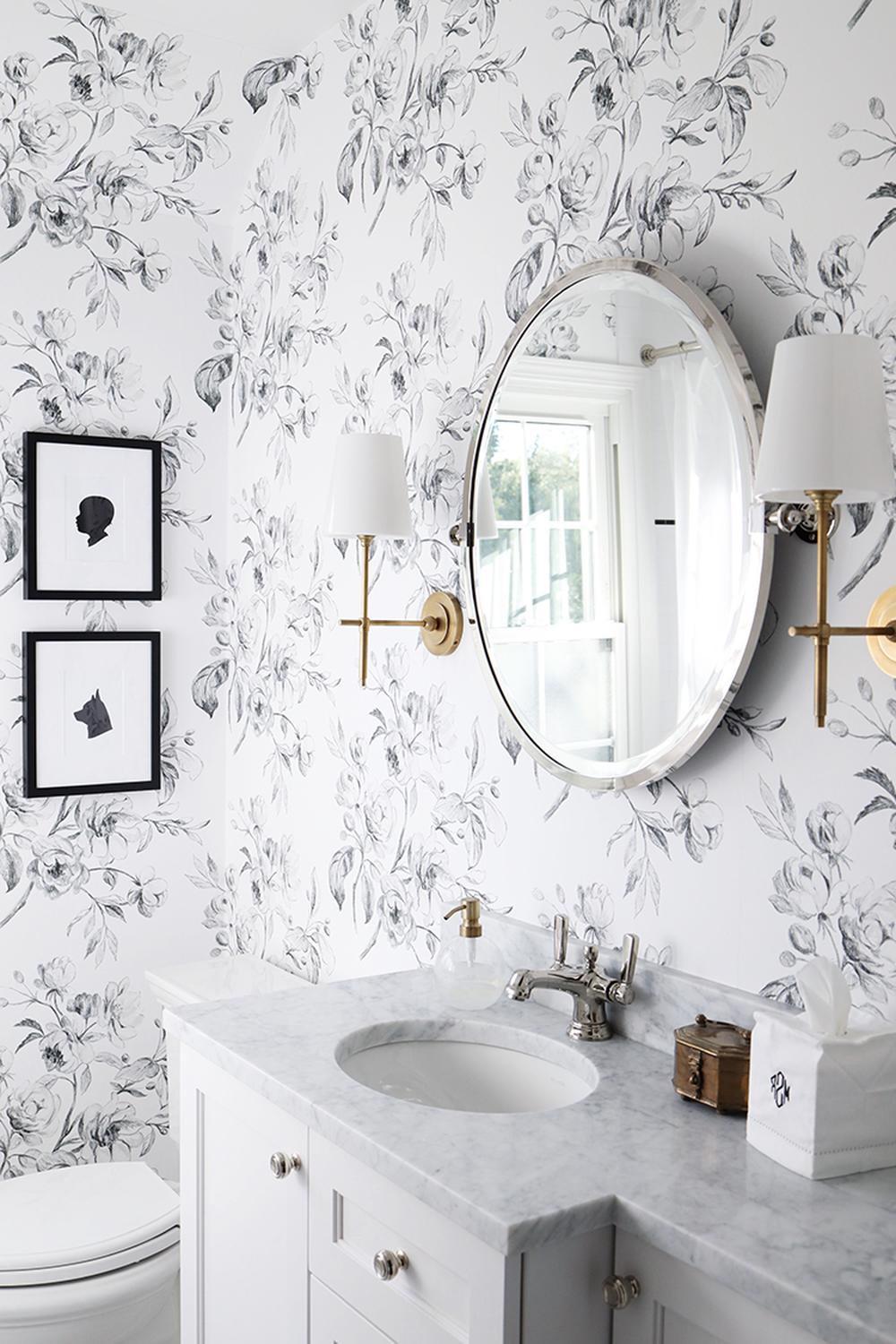 Stylish bathroom with delicate floral wallpaper in shades of gray.
