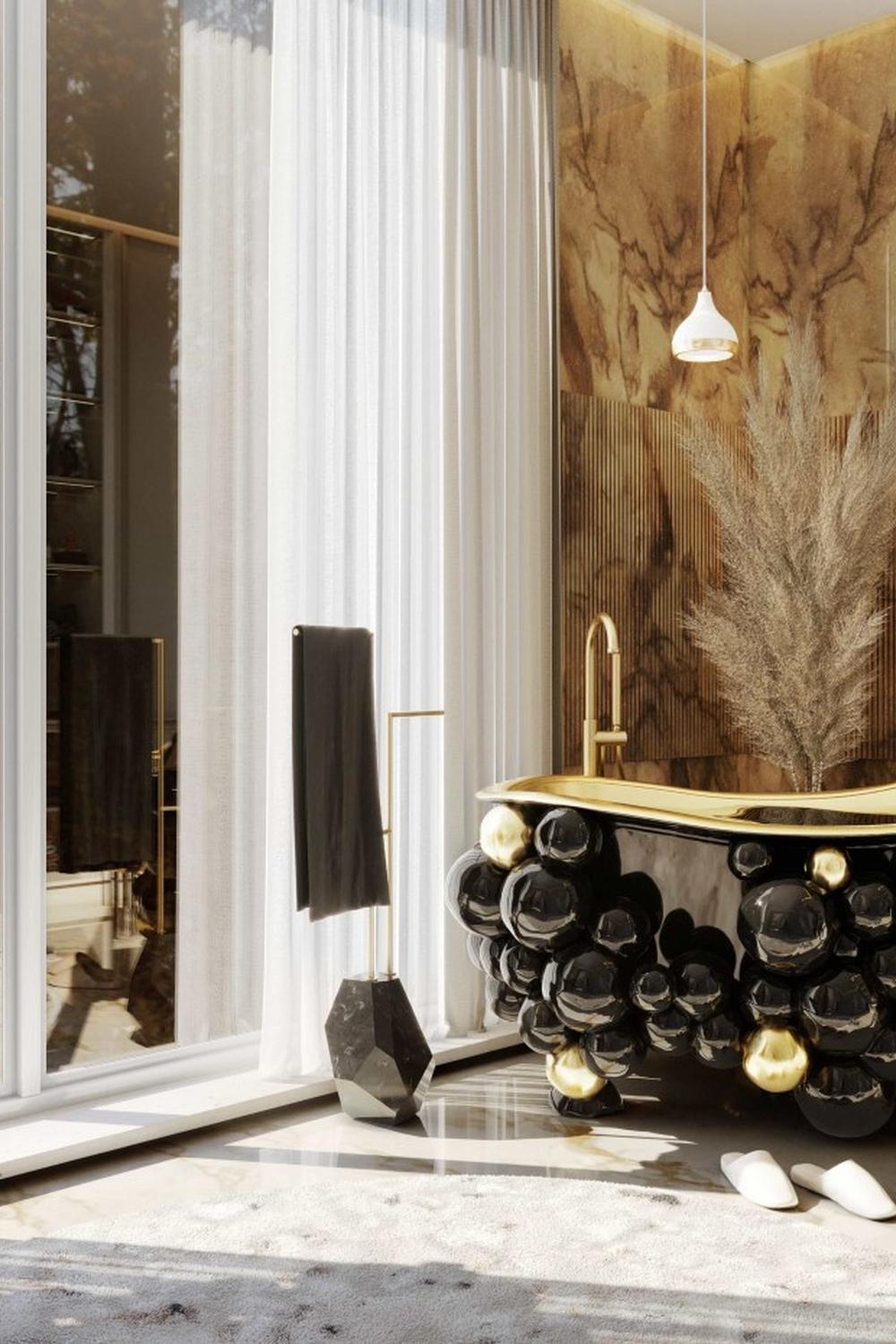 A luxurious bathroom featuring a black bathtub with gold rim, surrounded by warm tones and elegant accessories.