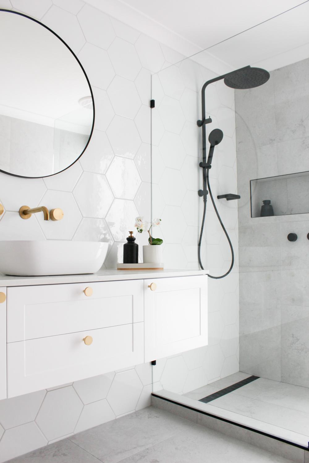 A modern bathroom with a seamless blend of black, white, and gold elements.