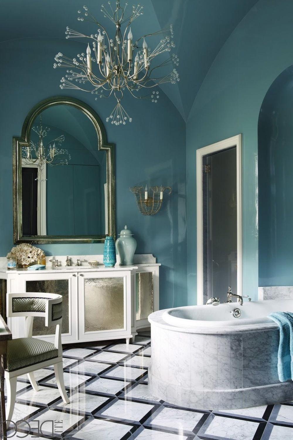 A stylish blue bathroom featuring a striking chandelier and deep blue walls