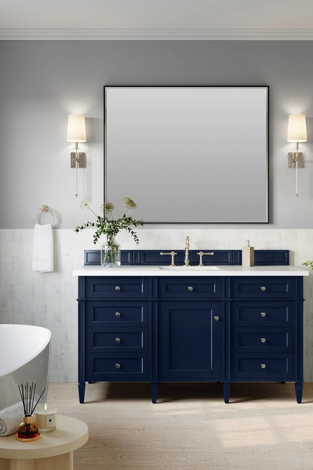 Navy blue bathroom vanity with a sleek white countertop and polished chrome faucets.