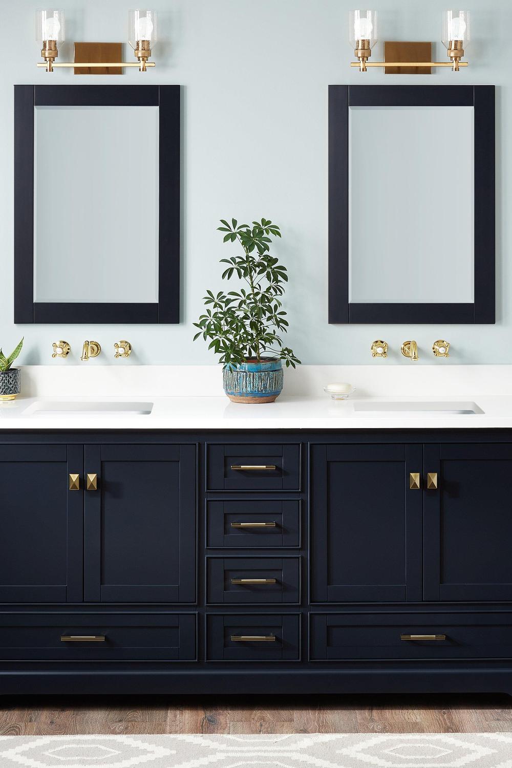Stylish blue bathroom vanity with gold-toned hardware in a bright bathroom.