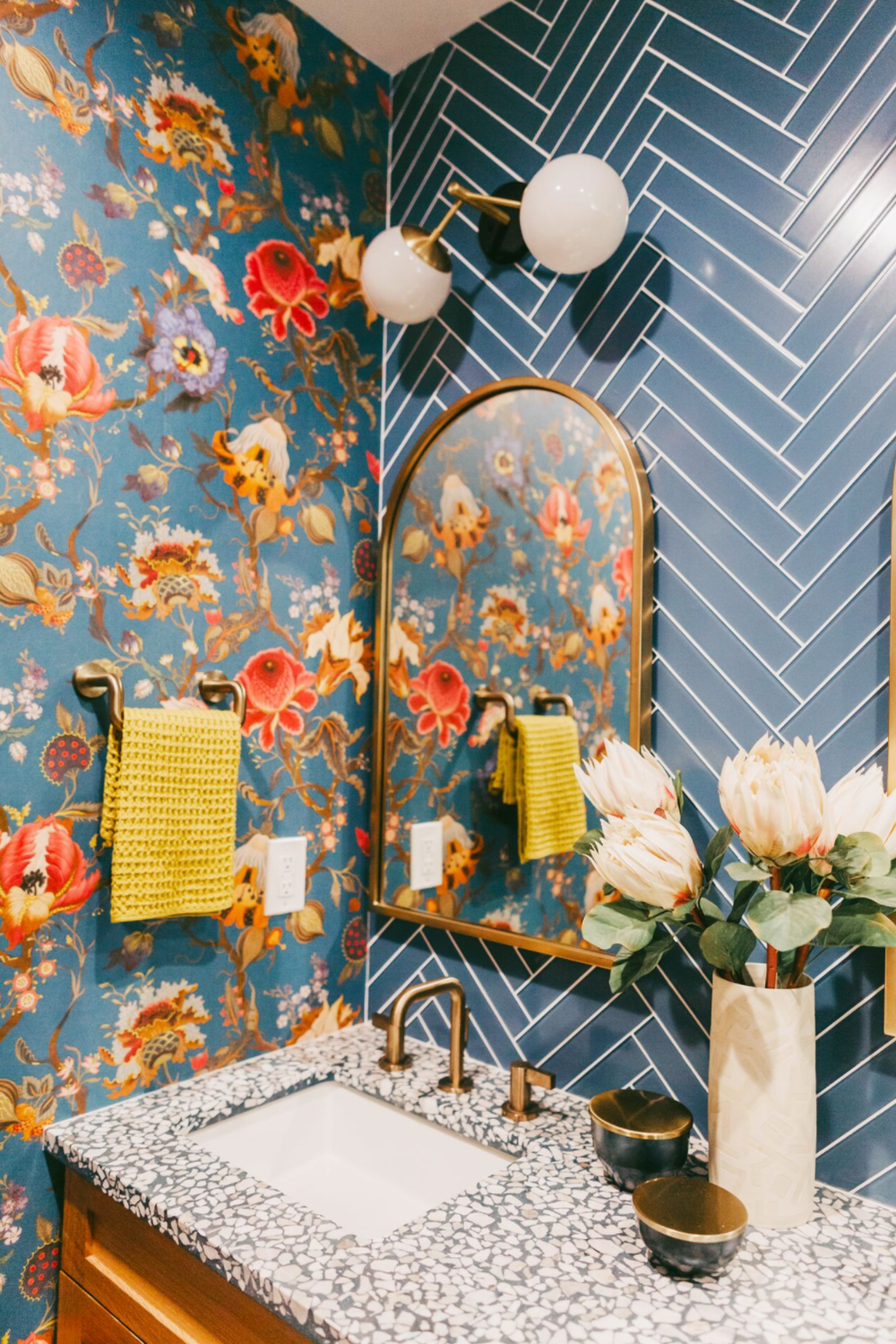 Baño con papel pintado floral en tonos azules y detalles vibrantes