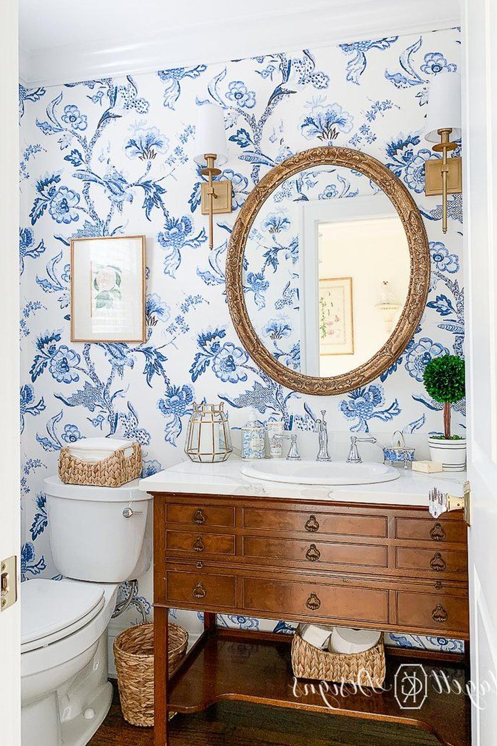 Baño con papel pintado azul floral que invita a la serenidad