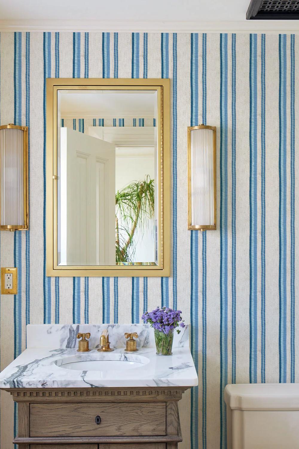 Baño acogedor con papel pintado a rayas azules