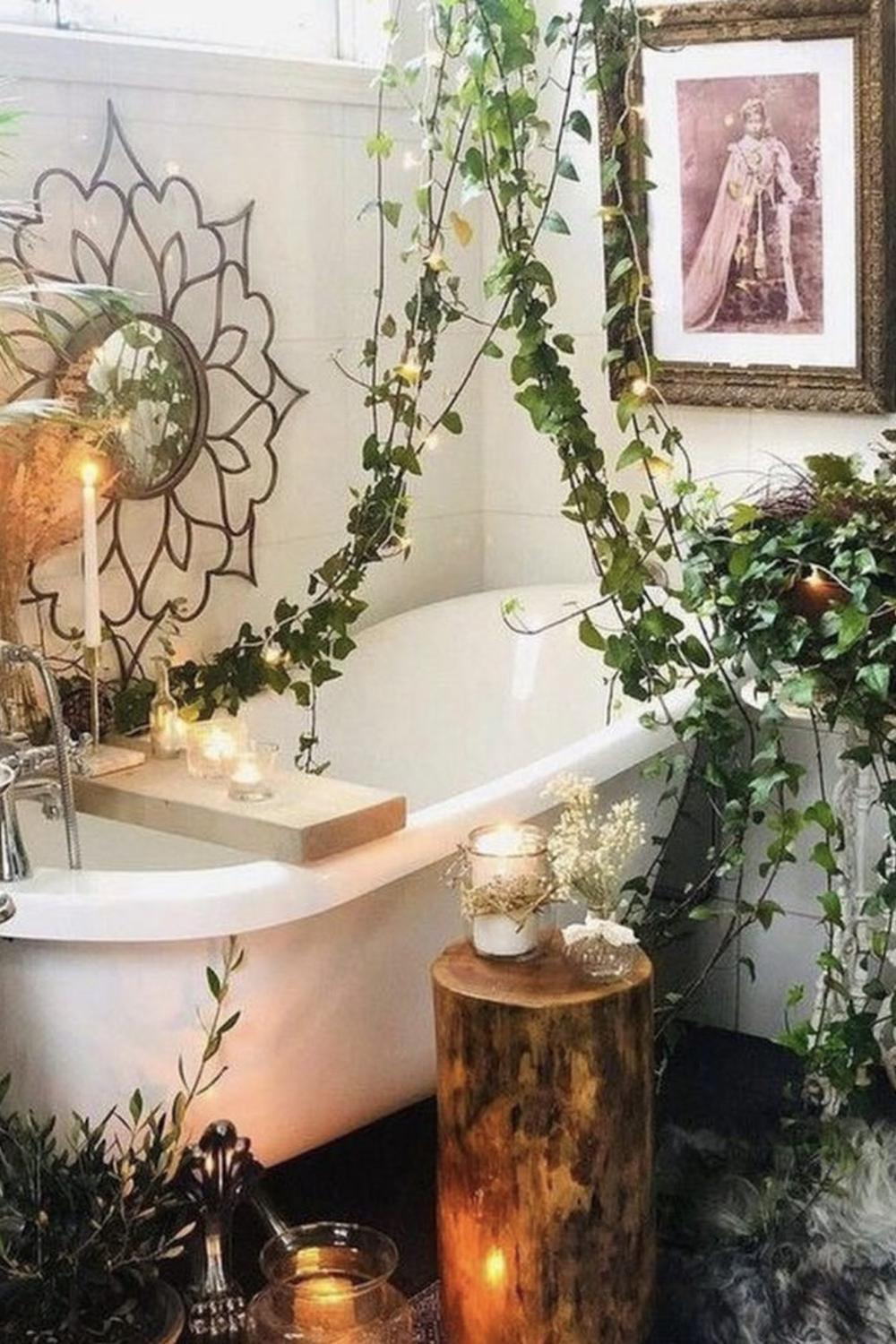 A bohemian bathroom filled with lush greenery and warm candlelight.