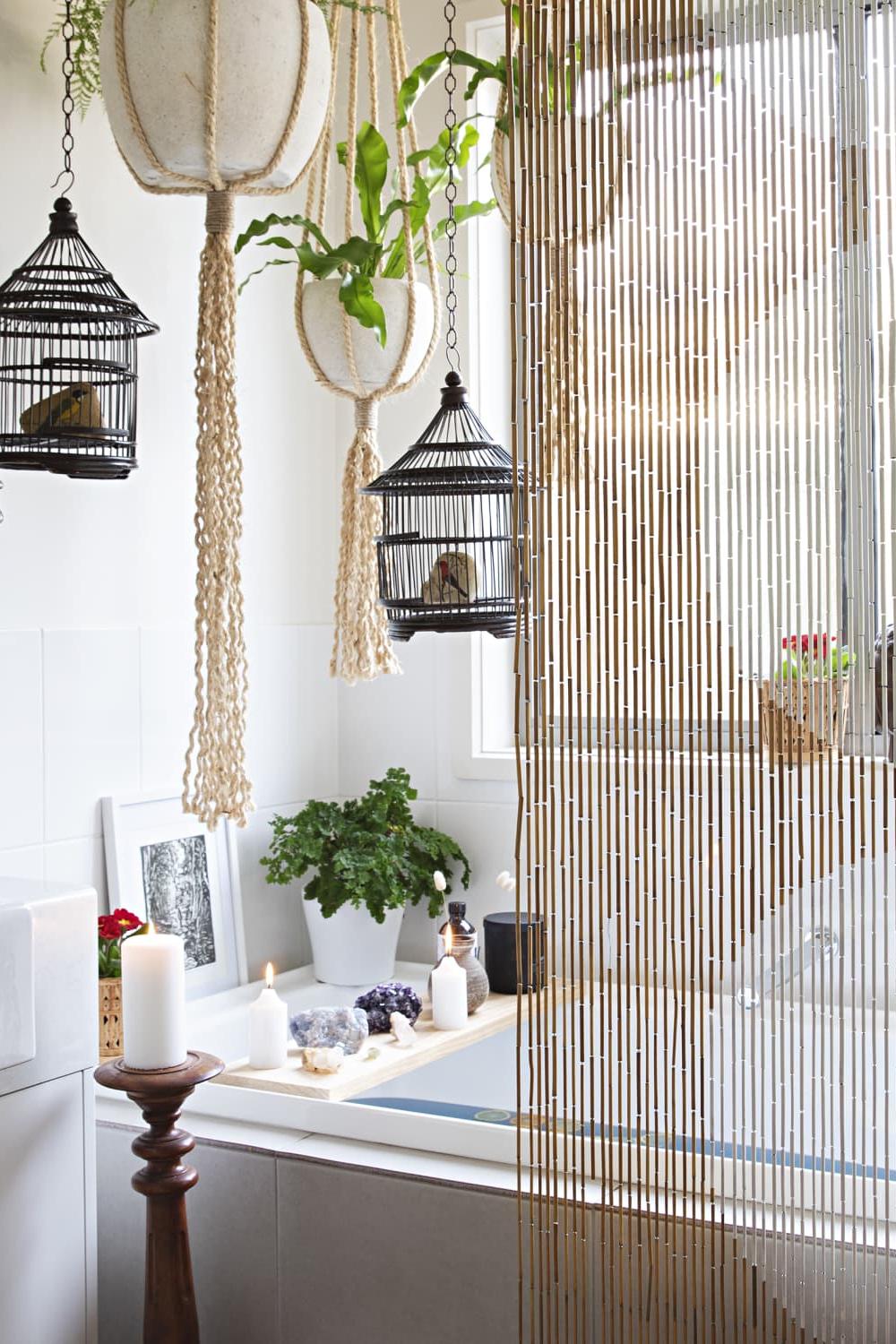 Baño boho con plantas colgantes y pantalla de bambú