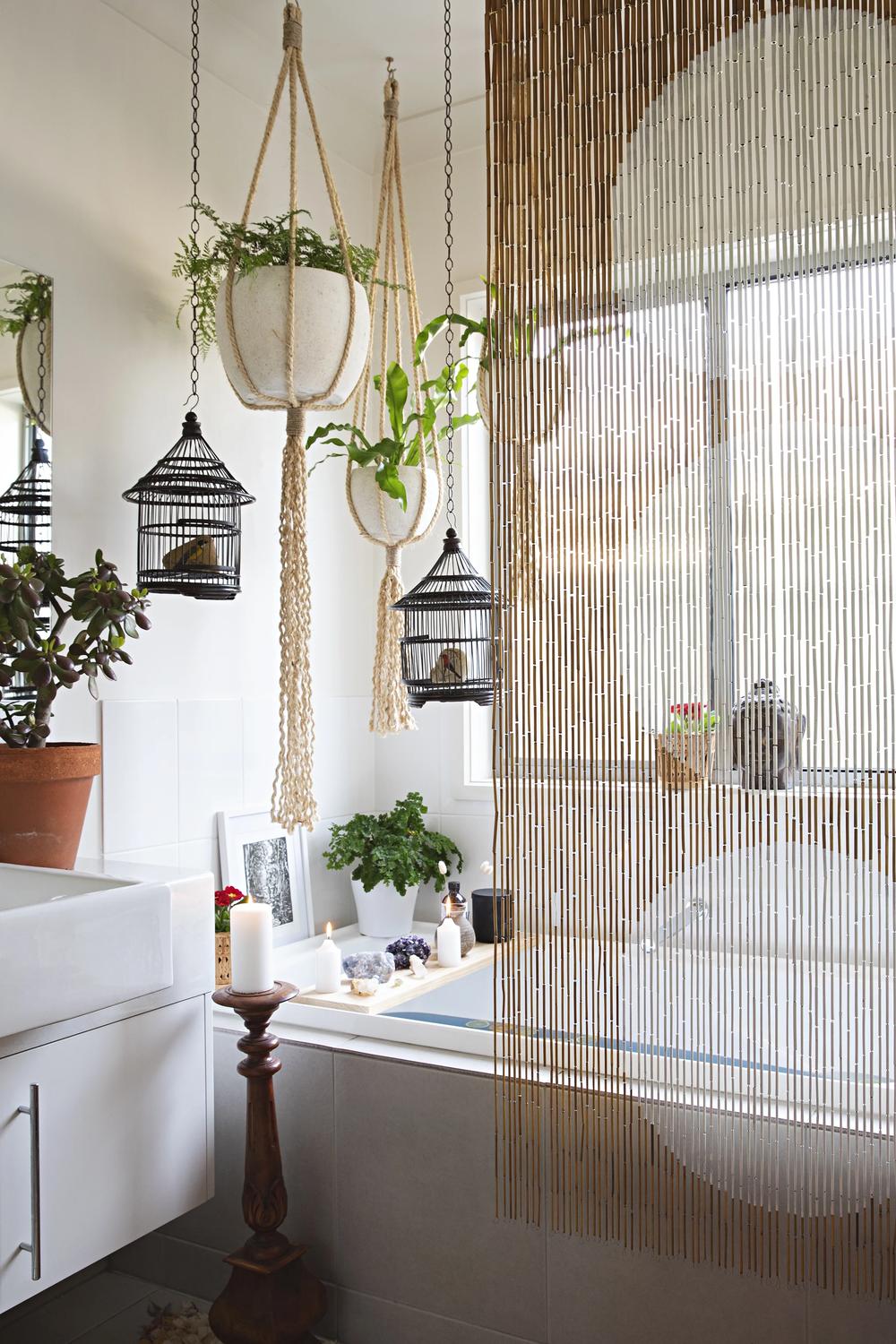 Baño boho elegante con maceteros colgantes