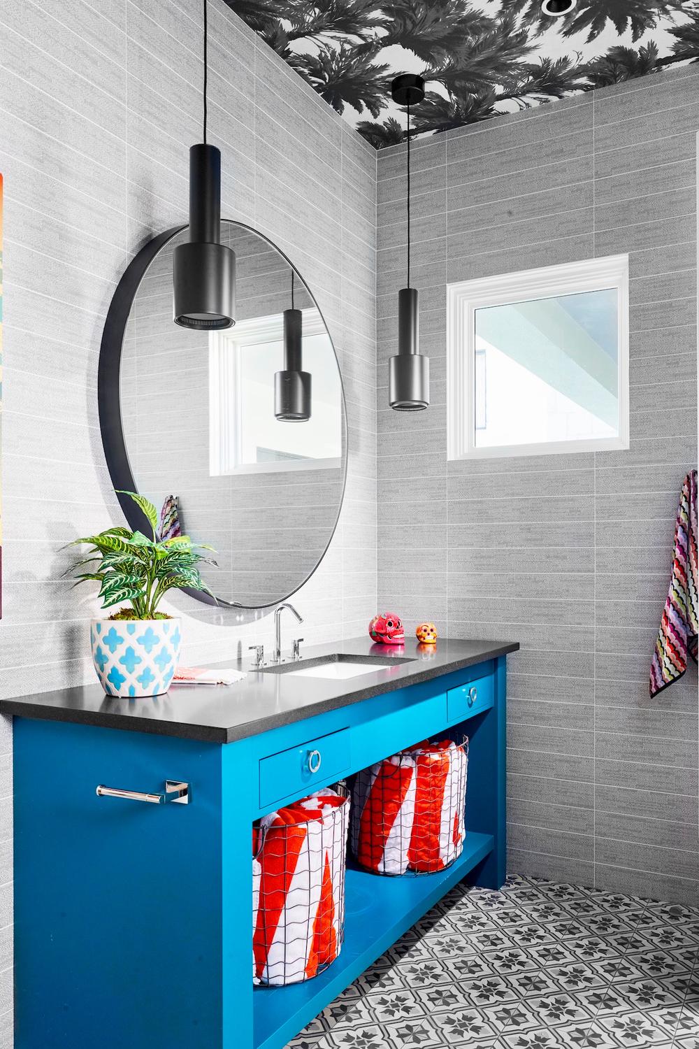 A boys bathroom showcasing a lively blue vanity and modern sink