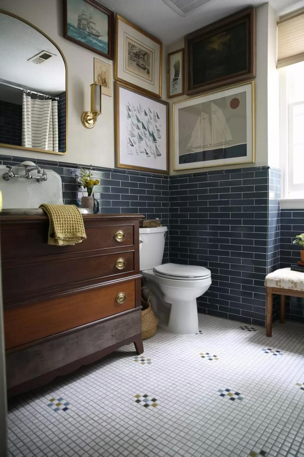 A nautical themed boys bathroom with dark blue tiles and fun decorations