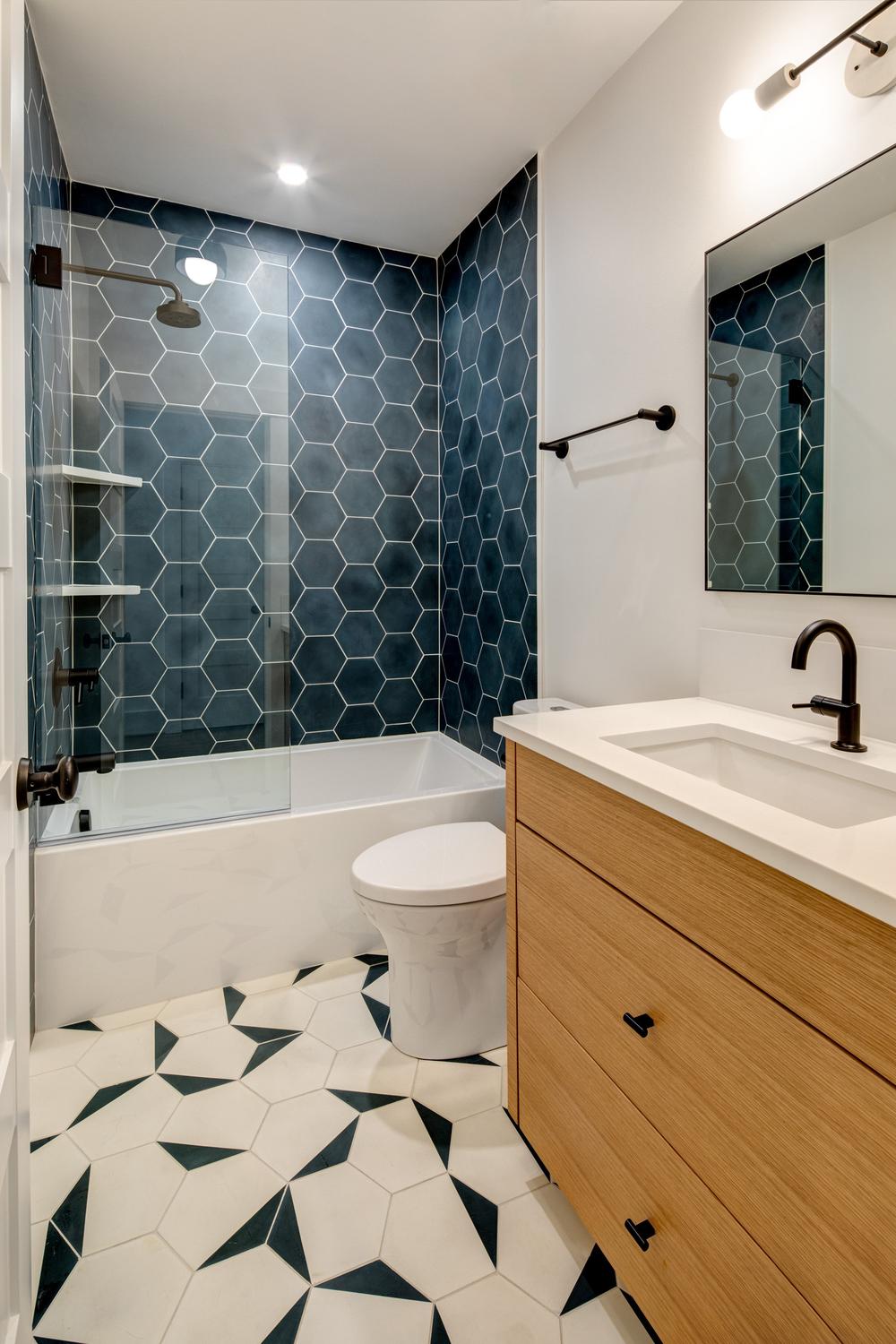 Stylish boys bathroom featuring hexagonal tiles and modern fixtures.