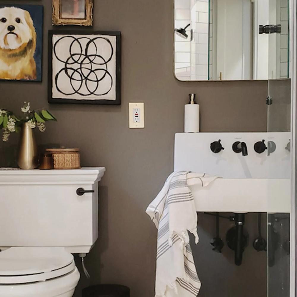 Decoración de baño moderna con colores grises y toques de arte colorido