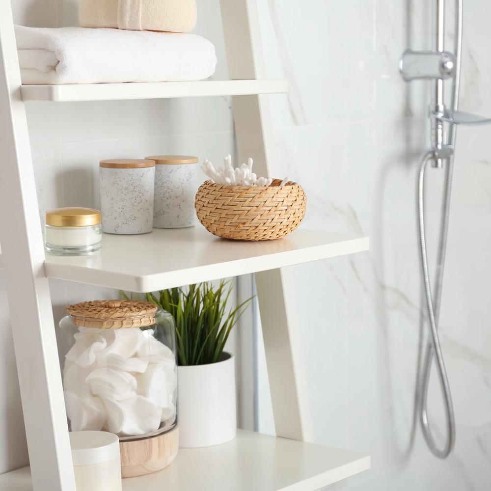 Contemporary ladder shelves elegantly organized with towels, decorative containers, and a potted plant.