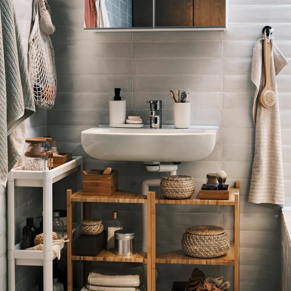Stylish bathroom setup with bamboo shelves maximizing space and showcasing various storage containers and baskets.