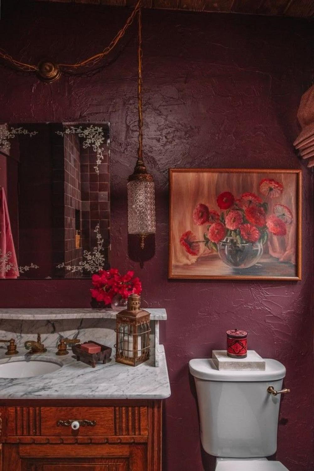 Baño vintage con elegancia en burdeos y detalles artísticos