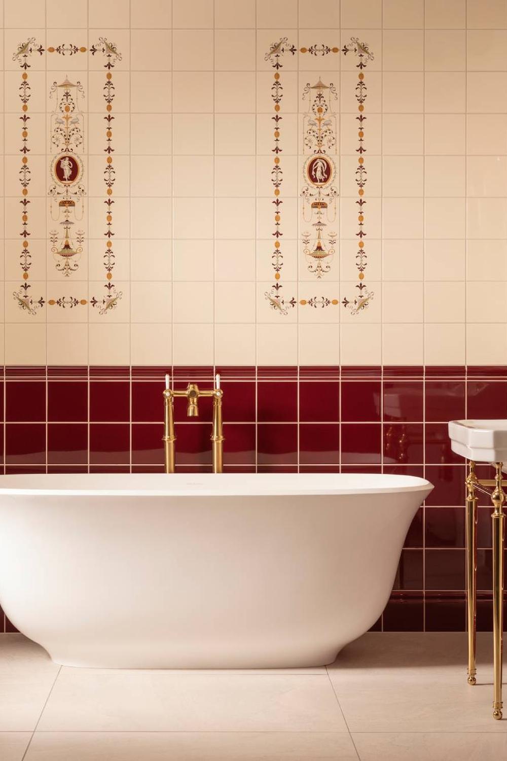 A luxurious bathroom featuring burgundy tiles and a stylish freestanding bathtub.