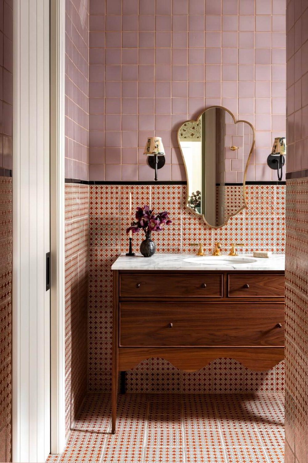 A stylish bathroom with burgundy and pink-toned tiles creating warmth.