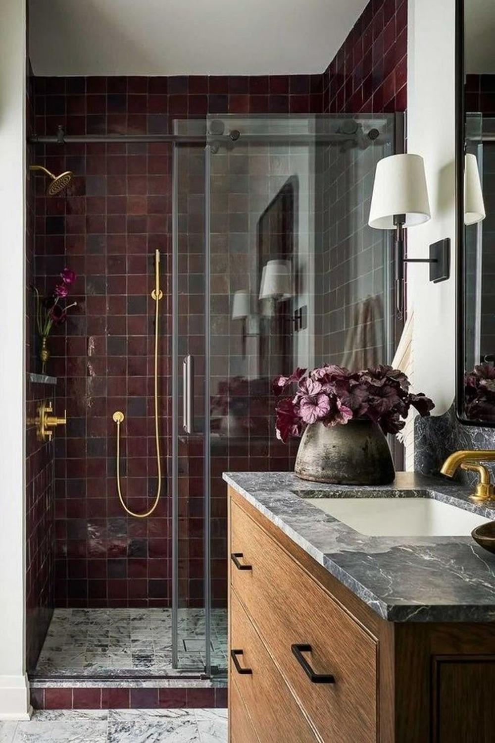 A luxurious modern bathroom showcasing burgundy tiles and a natural touch.