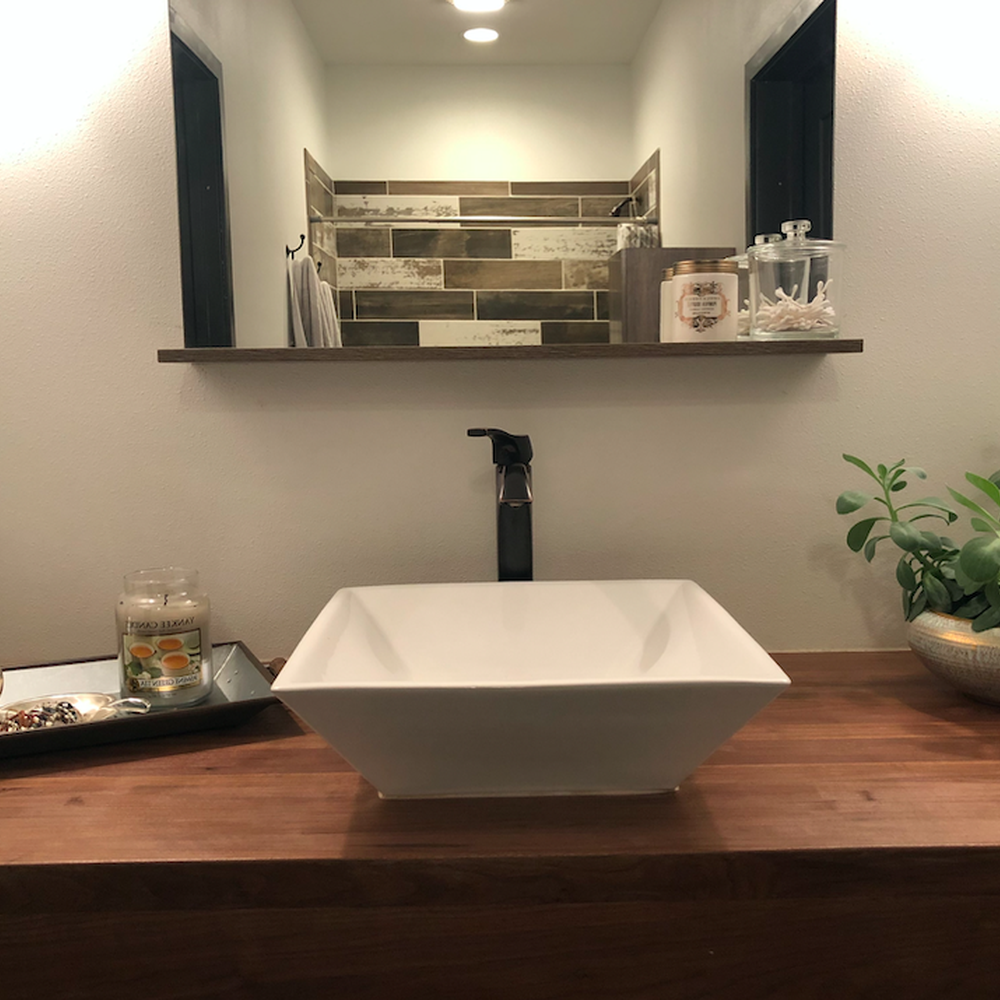 Contemporary bathroom with butcher block countertop, vessel sink, and matte black faucet