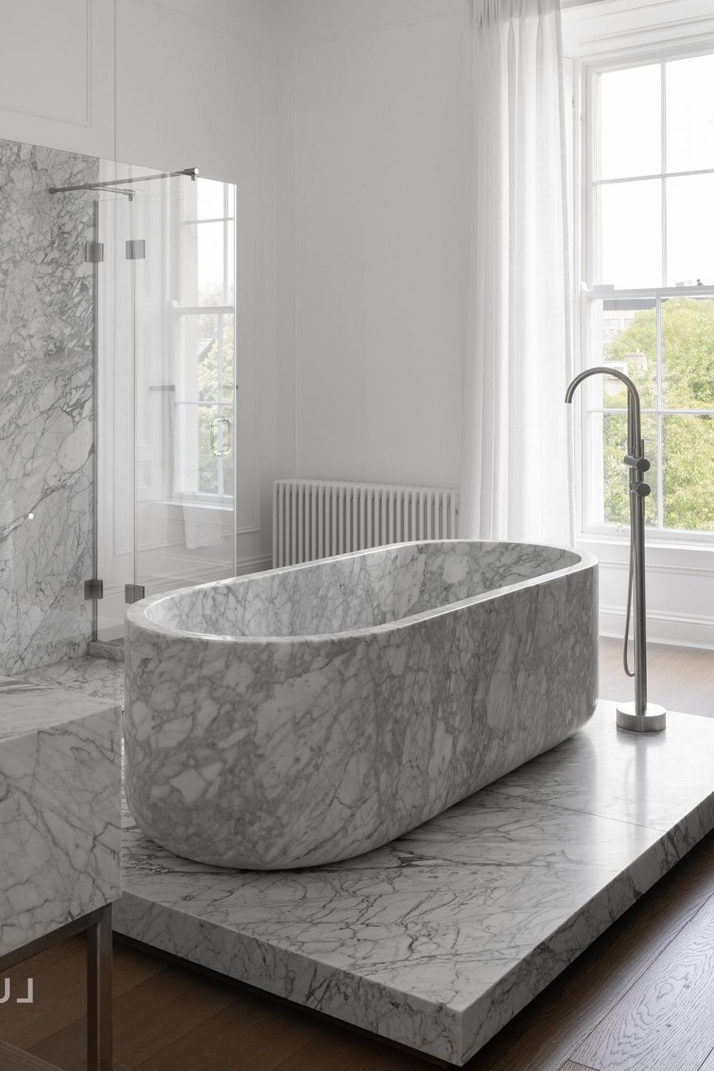 Bathroom showcasing stylish freestanding Carrara marble bathtub