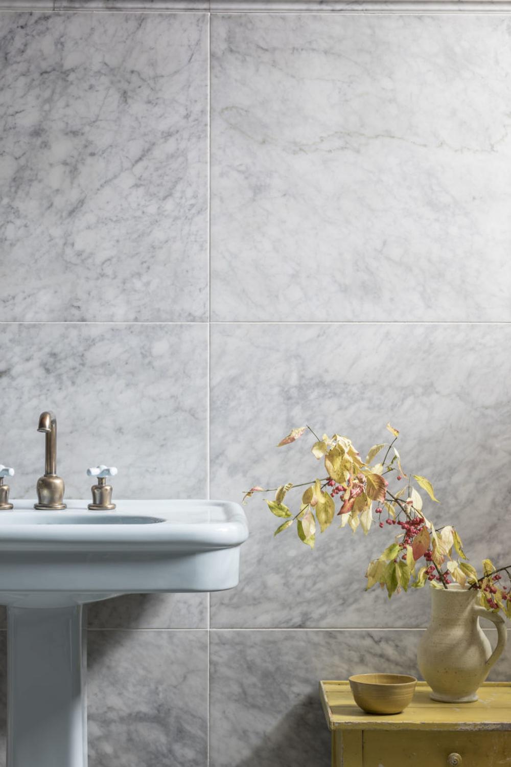 Charming bathroom with Carrara marble and delightful decorative accents