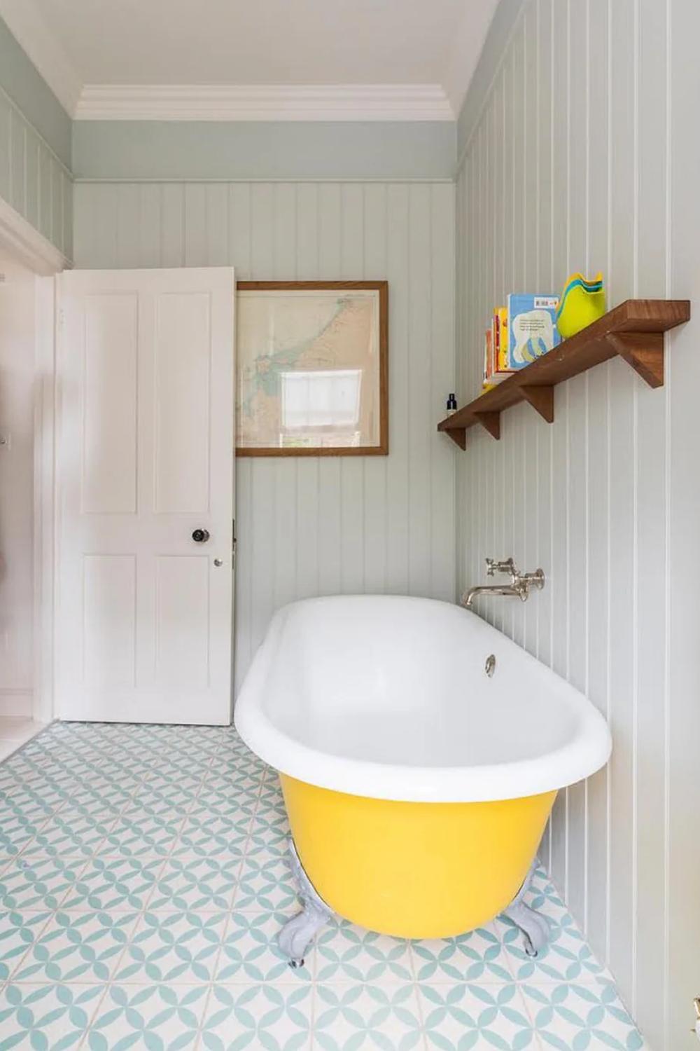 Family-friendly bathroom showcasing patterned cement tiles and a vintage-style freestanding bathtub.